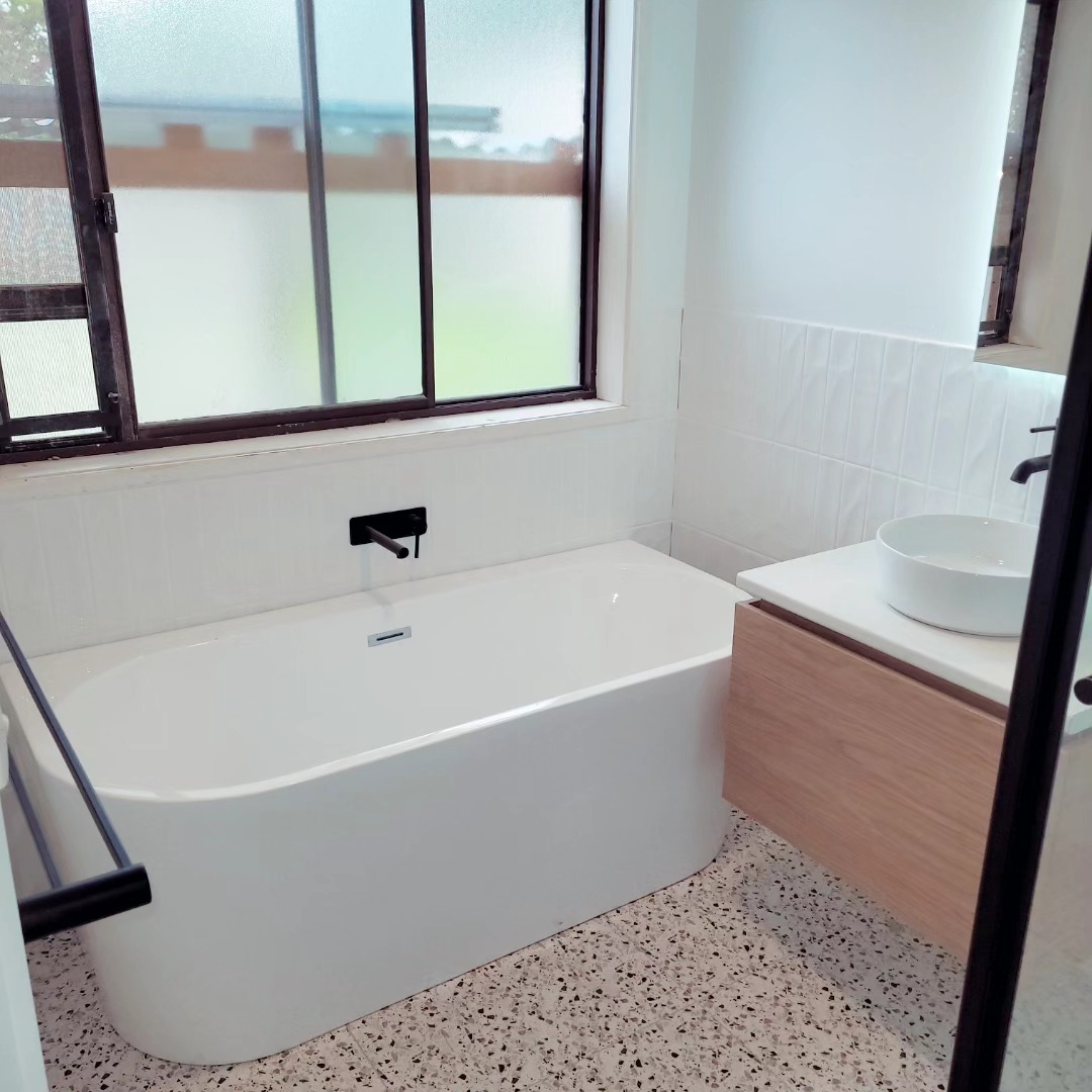 Bathroom renovation with a freestanding bath, black tapware and terrazzo floor